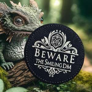 May include: Black leather coaster with a white design featuring a 20-sided die and the text "Beware the Smiling DM".