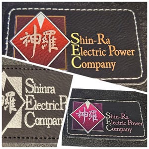 May include: Black leather patch with white stitching featuring the text "Shin-Ra Electric Power Company." The logo includes Japanese characters within a red and white diamond shape. The text is in gold.