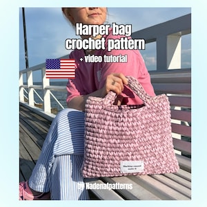 Puede incluir: Un bolso de ganchillo rosa claro con dos asas y una etiqueta rectangular blanca que dice Machine cannot make it. El texto Harper bag crochet pattern + video tutorial y una bandera de los Estados Unidos son visibles sobre el bolso.