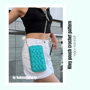 Op de afbeelding: Een rechthoekig turquoise gehaakt tasje met een dikke gevlochten textuur en een goudkleurige metalen kettingriem. De tekst "Riley pouch crochet pattern + video tutorial" en "by Nadenafpatterns" staat aan de zijkant van de afbeelding.