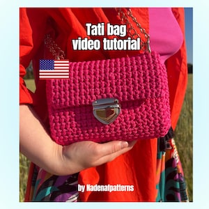 K&ouml;nnte beinhalten: Eine leuchtend pinke geh&auml;kelte Handtasche mit einem silberfarbenen Verschluss und einem goldfarbenen Kettenriemen. Der Text Tati bag video tutorial und by Nadenafpatterns ist sichtbar, zusammen mit einer kleinen US-Flagge auf der Tasche.