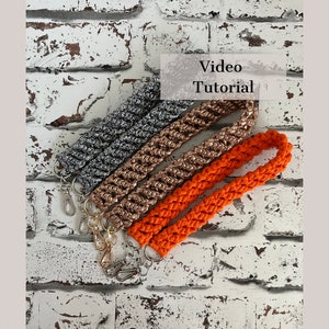 May include: Three crocheted straps in different colors: orange, rose gold, and silver. The straps have a braided design and are attached to silver key rings. The image includes the text "Video Tutorial".