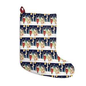 May include: White Christmas stocking with a repeating pattern of a couple in traditional Asian attire, with floating lanterns against a dark blue background. The stocking has a red loop for hanging.
