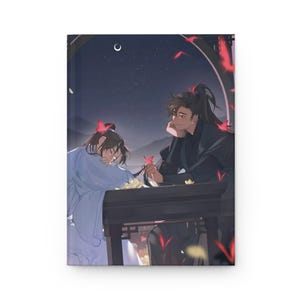 Puede incluir: Diario de tapa dura con una ilustración de estilo anime de dos figuras bajo un cielo estrellado. Una figura apoya la cabeza en una mesa, mientras que la otra sostiene una flor. La portada tiene una paleta de colores oscuros con acentos rojos y amarillos.