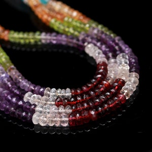 May include: A multi-strand necklace featuring faceted gemstone beads in a vibrant spectrum of colors. The strands include deep purple amethyst, bright green peridot, clear quartz, and rich red garnet, all arranged in a layered, curved design.