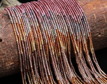 May include: Multiple strands of tiny, faceted gemstone beads in a gradient of colors ranging from deep burgundy and purple to amber, gold, and light yellow. The beads are strung on thin threads and arranged in a dense, cascading vertical pattern.