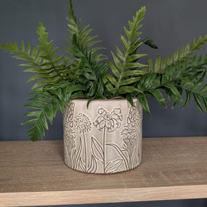 Maceta de cerámica botánica en relieve, soporte neutro para plantas de hierbas.