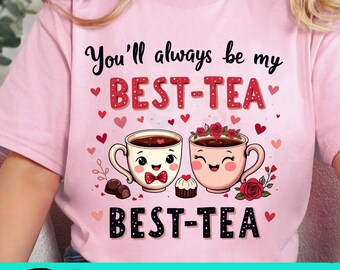 May include: Pink t-shirt with the text "You'll always be my BEST-TEA BEST-TEA" in red and white lettering. The design features two cartoon teacups with smiling faces and hearts.
