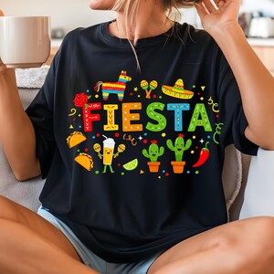 May include: Black t-shirt with a colorful "Fiesta" graphic featuring a pinata, maracas, tacos, cacti, and a lime.