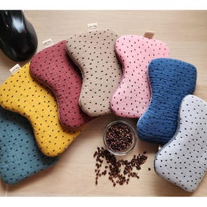 Könnte beinhalten: Ein Set aus sieben bunten, gemusterten Handgelenkauflagen, jede mit einer anderen Farbe und einem anderen Design. Die Handgelenkauflagen sind aus einem weichen, strukturierten Stoff gefertigt und perfekt, um Ihre Handgelenke zu stützen, während Sie an Ihrem Computer arbeiten.