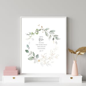May include: A watercolour print featuring a green and gold floral wreath with the text "I WILL Restore TO YOU THE YEARS THAT THE LOCUST HAS EATEN. Joel 2:25"