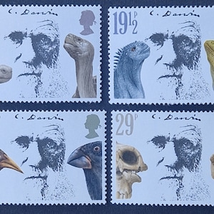 May include: A sheet of four postage stamps featuring a portrait of Charles Darwin. Each stamp includes a different illustration of a reptile, bird, or skull. The stamps are in shades of gray, brown, and blue, with the denomination and "C. Darwin" printed on each.