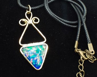 May include: A gold triangle pendant necklace with a blue, green, and pink iridescent glass triangle inside. The necklace has a black cord.