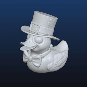 May include: A white rubber duck wearing a green top hat with a shamrock design and a white bow tie.
