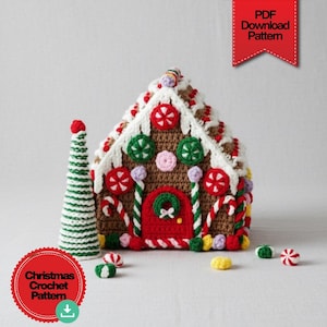 Op de afbeelding: Een gehaakt peperkoekhuisje met rode, groene en witte accenten. Het huis heeft een rode deur, snoepdecoraties en een wit glazuurdak. Een gehaakte kerstboom en snoepjes zijn ook aanwezig. De tekst "PDF Download Pattern" en "Christmas Crochet Pattern" is zichtbaar.