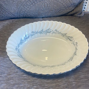 Może przedstawiać: Biała owalna miska do serwowania z niebieskim wzorem kwiatowym i falistym brzegiem.