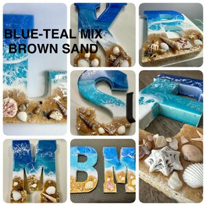 May include: Resin letters in blue, teal, and white, resembling ocean waves over brown sand, adorned with seashells. The letters include "J", "K", "E", "S", "M", and "BM". The text "BLUE-TEAL MIX BROWN SAND" is also present.