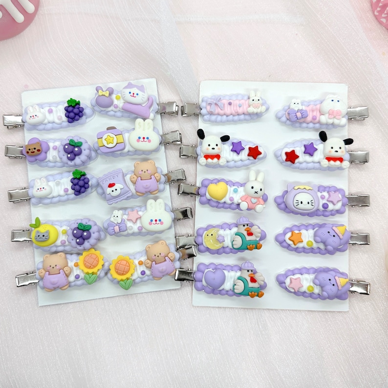 May include: Set of 18 purple and white hair clips with various cartoon animal and character designs. The clips are on two white cards.