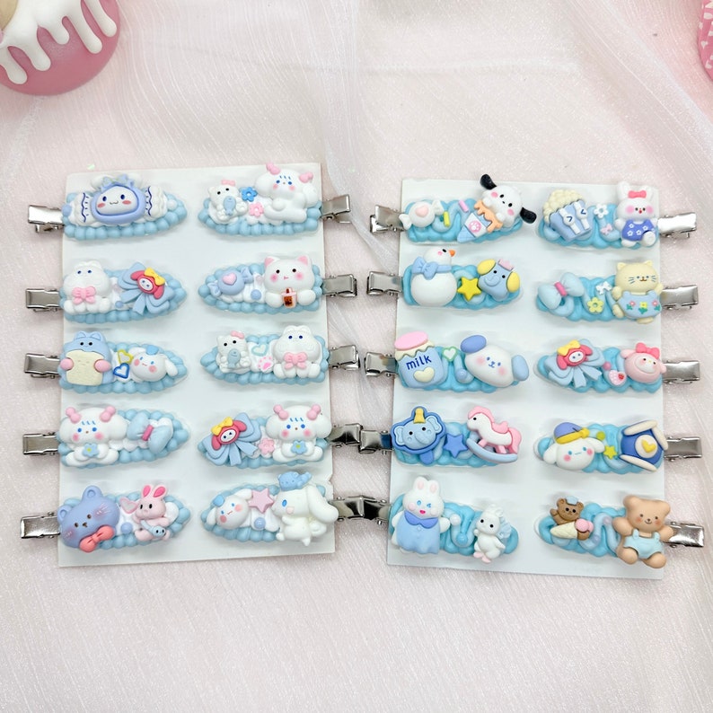 May include: A set of 20 blue and white hair clips with various cartoon animal designs. The clips are on a white background and feature designs such as a cat, a dog, a bunny, a unicorn, and a snowman.
