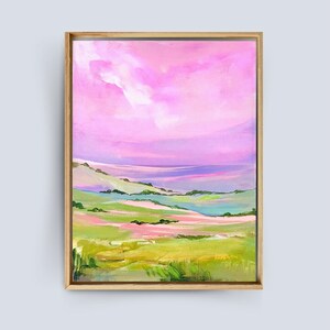 Puede incluir: Pintura abstracta de paisaje con un cielo rosa y morado y colinas verdes. La pintura est&aacute; enmarcada en un marco de madera claro.