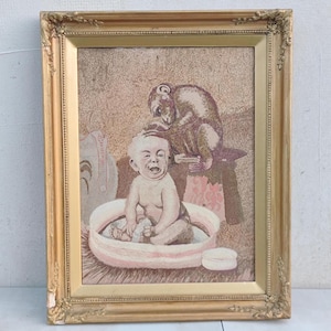 Puede incluir: Una pintura enmarcada de un bebé en una bañera con un mono sentado en el borde de la bañera. El bebé está riendo y el mono está mirando al bebé.