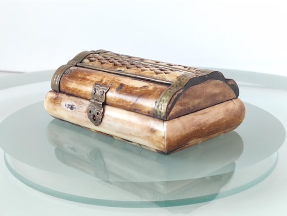 A tiny jewelry box built from real antler and animal bone with brass accent hardware — genuinely weird, tactile, and conversation-starting in the best way.