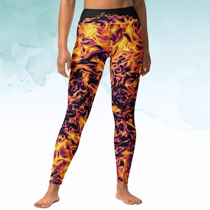 May include: High-waisted leggings with a vibrant, fiery pattern. The leggings feature a black waistband and a repeating design of swirling orange, yellow, and purple flames. The leggings are form-fitting and reach the ankles.