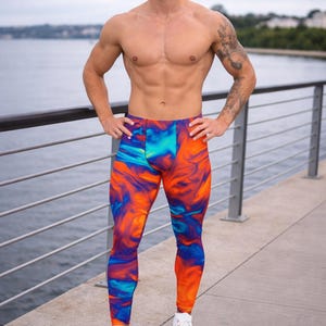 May include: Vibrant leggings with a swirling pattern of orange, blue, and turquoise. The leggings are form-fitting and paired with white sneakers. The overall look is athletic and eye-catching, perfect for workouts or casual wear.
