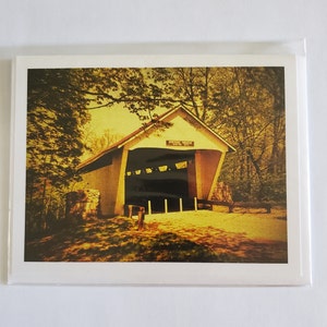 May include: A vintage photograph of a covered bridge with the text "Foster Bridge" above the entrance. The bridge is surrounded by trees and the image has a sepia tone.
