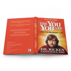 May include: An open book titled "THE YOU YOU ARE" with a red cover and spine. The cover features a portrait of Dr. Ricken Lazlo Hale, PhD. The book's subtitle reads "A Spiritual Biography of You."