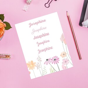 Könnte beinhalten: Eine weiße Karte mit dem Namen Josephine, der fünfmal in rosa Kursivschrift geschrieben ist. Die Karte ist mit Aquarellblumen in Rosa-, Orange- und Gelbtönen verziert.