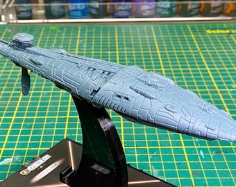 May include: A gray, detailed, spaceship model with a textured surface. The model is on a black stand.