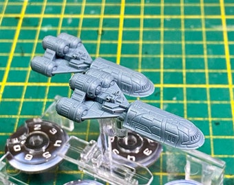 May include: Two gray plastic miniature spaceships with detailed designs. The spaceships are on clear plastic stands.