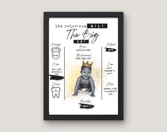 May include: A black and white photo of a baby boy wearing a gold crown. The photo is on a white background with gold glitter. The text "The Big One" is written in black cursive. The text "the notorious NILE" is written in black. The text "Born April 19th 2022" is written in black. The text "Nicknames Duck, Baby, Nile" is written in black. The text "I weigh 19 lbs" is written in black. The text "I stand 30 in" is written in black. The text "I can" is written in black. The text "I am" is written in black. The text "I have" is written in black. The text "I love" is written in black. The text "Favorites" is written in black. The text "Jools TV" is written in black.