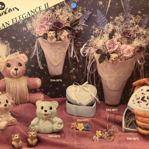 Puede incluir: Una colección de figuritas de cerámica, que incluyen un oso de peluche rosa con un sombrero y un collar de flores, un oso de peluche azul claro, un oso de peluche rosa y dos osos de peluche marrones más pequeños. También hay tres jarrones de cerámica con arreglos florales y dos cajas en forma de corazón.