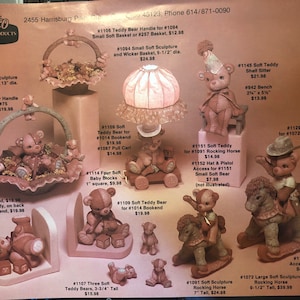 Puede incluir: Una colección de esculturas de osos de peluche de cerámica, que incluyen un oso de peluche sentado en una cesta de mimbre, un oso de peluche sosteniendo un bloque de bebé y un oso de peluche montando un caballo de balancín. Las esculturas están pintadas en tonos suaves de rosa y blanco.