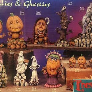 Puede incluir: Una colección de figuritas de cerámica con temática de Halloween, que incluyen calabazas, fantasmas y un árbol espeluznante. Las figuritas están pintadas en varios colores, incluyendo naranja, verde, blanco y negro. Las figuritas están dispuestas en un estante de madera con un fondo morado.