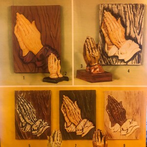 May include: Nine different wood carvings of praying hands, each with a different wood grain and colour. The carvings are all in the same pose, with the hands clasped together in prayer. The carvings are all on a white background. The text "DECORATING Ideas 10¢" is at the top of the image.