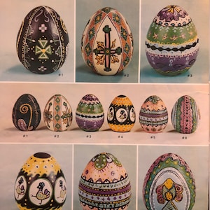 May include: Nine decorated Easter eggs with various designs, including geometric patterns, flowers, and birds. The eggs are painted in vibrant colours, such as green, purple, yellow, and black. The image is from a vintage craft book titled "Duncan Bisq-Stain Ukrainian Eggs Technique".