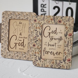 May include: Two rectangular wooden frames with rounded corners. The left frame features a bird pattern and the text "be Still & know that I am God PSALM 46:10". The right frame has a floral pattern and the text "God is the strength of my heart and my portion forever PSALM 73:26".