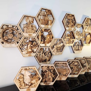 May include: A set of 13 wooden hexagonal wall art pieces with intricate laser-cut designs. Each piece features a different scene, including a clock, a dragon, and a group of people. The pieces are arranged in a honeycomb pattern on a white wall.