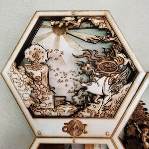 Puede incluir: Un marco hexagonal de madera con un diseño cortado por láser que representa una escena fantástica con un lobo, un árbol y un sol. El marco forma parte de un conjunto más grande de marcos hexagonales.