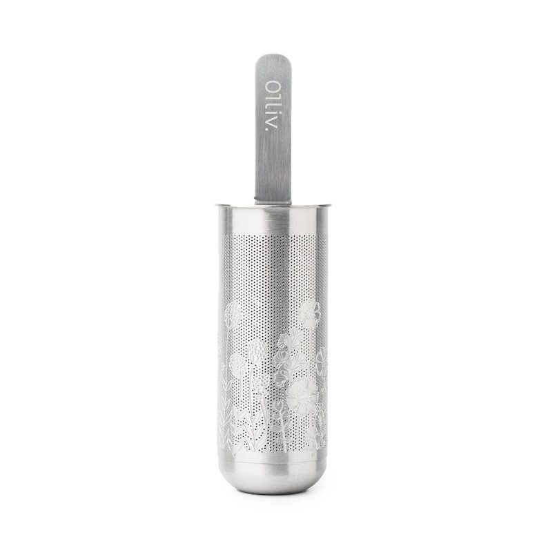 May include: A silver tea infuser with a floral design and a long handle. The handle has the word "OLIV" printed on it.