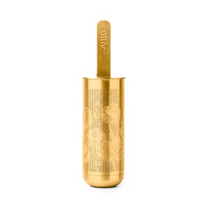 May include: Gold-colored tea infuser with a floral design and a wooden handle. The handle has the word "OLIV" engraved on it.