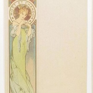 May include: A vintage art nouveau poster featuring a woman in a flowing green dress, holding a glass of champagne. The poster is framed in a gold border and features the text "Moet et Chandon" in a circle.