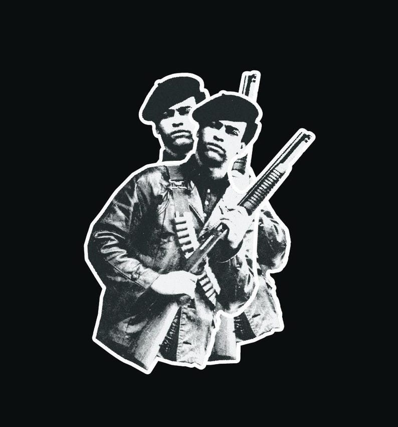 May include: Black and white photograph of a man holding a shotgun. He is wearing a beret and a jacket. The photo is cropped to show only the man and the gun.