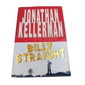 Könnte beinhalten: Ein Hardcover-Buch mit dem Titel "Billy Straight" von Jonathan Kellerman. Das Cover hat einen roten und weißen Hintergrund mit dem Namen des Autors in Weiß und dem Titel in goldener Schrift. Eine kleine Illustration einer angelnden Person ist ebenfalls vorhanden.