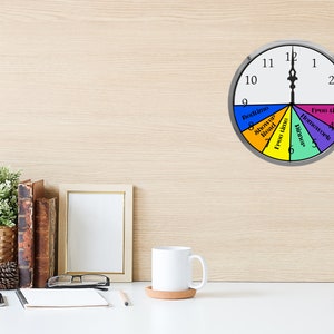 May include: A colorful clock divided into sections for different activities, such as bedtime, shower, free time, dinner, and homework. The clock face is white with black numbers and hands. The sections are colored red, orange, yellow, green, and purple.