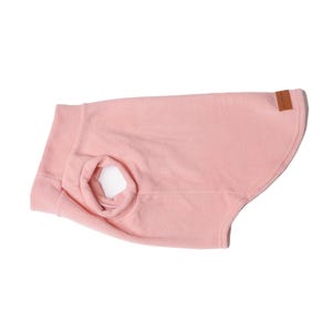 Könnte beinhalten: Ein rosa Fleece-Hundepullover mit einem runden Halsausschnitt und einem kleinen braunen Etikett auf der Rückseite.