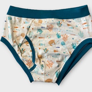 May include: White underwear with a teal blue waistband and a sea life print featuring fish, jellyfish, crabs, and coral.